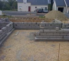 Après achevement des semelles en béton armé. Début des rangs de parpaings pour le vide sanitaire sous maison et garage.