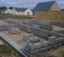 Après achevement des semelles en béton armé. Début des rangs de parpaings pour le vide sanitaire sous maison et garage.