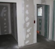 Prises installées avec protection de chantier et chape en cours de séchage (chambre, dressing et salle de bains)