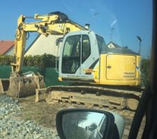 Le terrassement va bient&ocirc;t commencer. L'engin est pos&eacute; devant le terrain.