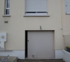 Ancienne porte de garage coulissante en fer. On a ragrandit l'ouverture de 2m à 2m40 et fait poser une porte de garage sectionnelle motorisée. Et pour faire un ensemble avec la porte d'entrée : j'ai acheté des baguettes pour tuning voiture et en et fait des carrés.