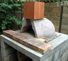 On voit ici la table sur une dalle au sol. Le four lui-même acheté et posé sur un lit de mortier maigre. Et un premier boisseau.