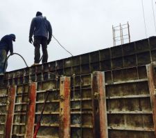 Les maçons vibrent le mur béton du RDC