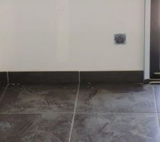 Mise en place des plinthes taillées dans des carreaux.
