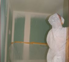 Monsieur en train de mettre la finition plafond dans la salle de bain (1ère couche)