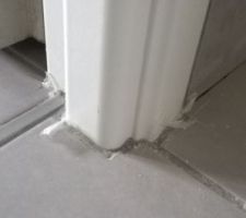 Plastiques pris dans le carrelage et traces de découpes sur le carrelage