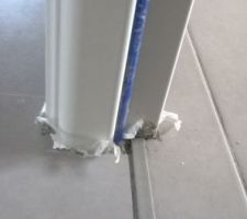 Plastiques pris dans le carrelage et traces de découpes sur le carrelage