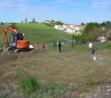 Le pelliste en action ainsi que le maçon pour l'implantation des puits qui seront forés l'après-midi