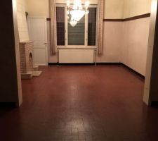 Vue sur la salle à manger depuis le salon.
La cheminée sur la photo va être détruite, le chauffage déplacé et la fenêtre va être cassée pour être transformée en baie vitrée.
Le carrelage (tomette rouge) est sain et stable et je vais pouvoir re-carler par dessus.