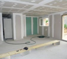 La piece de vie avec la cuisine au fond a droite, le couloir a gch et la porte de wc ouverte