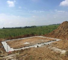 Fondation sur terres pleines pour notre double garage situé en fond de terrain (sur nos 700 m2).
En conséquent, derrière ce garage s'étend un terrain de 1500 m2 encore (repousse de blé).