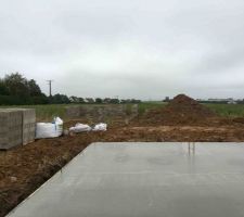 Dalle coulée pour notre maison.
En arrière-plan, on devine les débuts de notre garage avec les premiers parpaings.