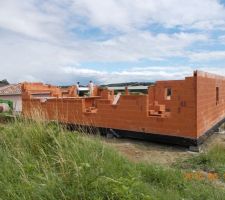 14 juin 2016 : L'élévation des murs arrive à son terme. Le côté ouest est terminé avec la fenêtre de salle de bains et le côté nord encore à monter. On commence à situer de ce côté la fenêtre d'une chambre à droite, la fenêtre d'un WC, la fenêtre d'une autre chambre et à gauche, la fenêtre du garage. A l'arrière plan, le côté SUD avec les deux baies sur terrasse et la fenêtre du cellier.