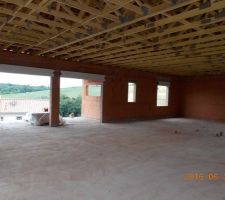 Vue de l'int&eacute;rieur prise depuis le garage. Vue du mur SUD. Les deux baies vitr&eacute;es, la fen&ecirc;tre du cellier et celle d'une chambre.