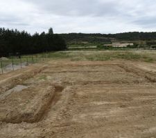 Terrassement du terrain. Creusage des rigoles de fondation et étalage sur la périphérie des terres de fouille.