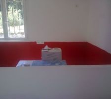 Peinture derrière le bar de la cuisine ouverte de couleur rouge.
