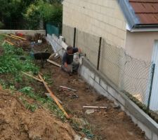 On construit un mur sur le cot&eacute; droit du terrain afin que la terre ne parte pas chez le voisin lorsqu'on remblaiera ...