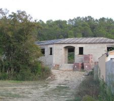 Vue extérieur, de l'avant, de la maison complètement recouverte de l'écran sous toiture.