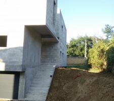 Le terrassier a mis en forme la butte le long de l'escalier, et le menuisier a posé et bloqué la porte de garage.