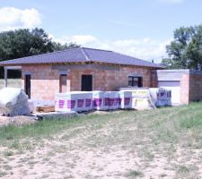 Charpente d'un coté avec tuiles noires, toiture terrasse de l'autre coté (garage)