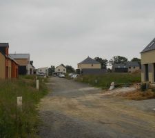 Voici la rue de la maison. Résolument ... "nature". Ça a son charme :)
Mais ça sera mieux d'ici quelques années, vu les lourdes obligations qu'on a côté aménagement paysagé, ça sera bien plus "vert" que là !
