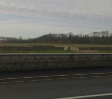 Terrain vu de la route avec le muret presque fini