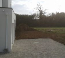 Vue de l'ouest de la maison. Au total, entre l'entrée, la place devant le garage et l'aire de stationnement, y'en a pour 125m²de stabilisé.
