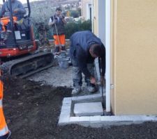 Préparation du chantier en pavé gris avant la pose du goudron.