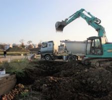 Pelle en action avec un des 8 camions