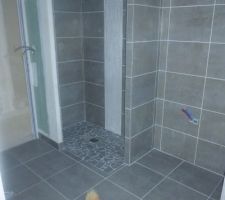 Salle de bain principale avec douche italienne, carrelage et faience dans quasi toute la pièce