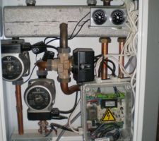 Le répartiteur avec en gris clair en haut, le réservoir de répartition dont les soudures ont lâchées, au centre la vanne 3 voies, qui s'est grippée, en bas à droite, le boitier de commande avec les deux câbles blancs des thermostats d'ambiance.