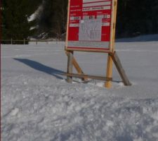 Le panneau sur le terrain enneigé ; gros cristaux de neige au premier plan.