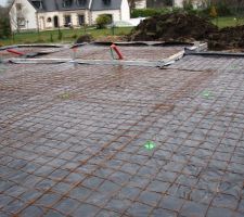 Préparation pour la dalle plancher avec la mise en place des différents tuyaux (électricité, évacuations...), du film polygane (étanchéité de la dalle) et du ferraillage.