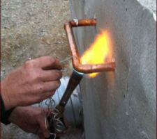 Soudure des tuyaux en cuivre à l'extérieur du local de stockage de chaleur