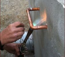 Soudure des tuyaux en cuivre à l'extérieur du local de stockage de chaleur