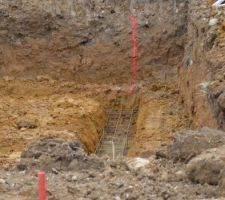 Treillis pour fondations, avec les piquets en rouge délimitant à 1 mètre de chaque coté l'emplacement final de la maison