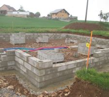 Elevation du vide sanitaire sous la pluie, les maçons ont bien du courage!