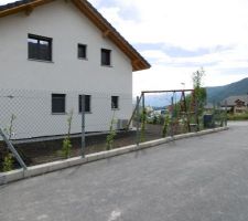 Clôture au nord (grimpantes plantées derrières) et à l'ouest et trottoir sur ces 2 côtés également, terrasse en dalle béton, gazon semé sur cette même moitié du jardin