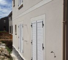 Enduit gratté extérieur terminé sur la façade arrière. modénature ligne séparant l'étage et contours de porte-fenêtre