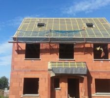 Pose de la charpente avec un écran de sous-toiture et des velux. Porche d'entrée de maison