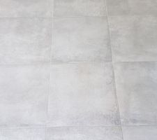 Carrelage au sol de plus près. Les joints gris se fondent dans le carrelage