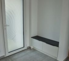 Hall d'entrée. Porte vitrée blanche.