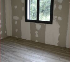 Chambre avec le carrelage imitation parquet.