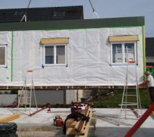 Vue intérieur des murs posés avec OSB à l'exterieur, ossature en bois, isolation entre solives, par vapeur et menuiseries encastrés avec volets electriques sauf BSO sur la terrasse dans le L