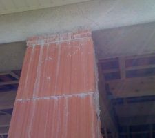 Pilier qui soutient la charpente d'un garage abri.