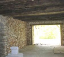 Ouverture de la pi&egrave;ce principale de la fermette sur l'extension. Sous le panneau, &agrave; doite, la cave ceus&eacute;e dans la roche.