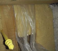 Petite astuce pour insérer des panneaux en fibre de bois facîlement sous les pannes. Les envelopper dans du polyane comme une papillote.