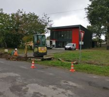 La tranchée pour l'électricité est en cours de creusement. En arrière plan camionnettes de l'électricien et du peintre.