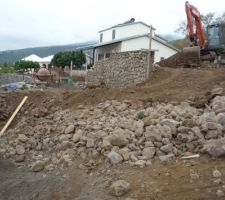 Terrassement du terrain sur 2 niveaux .
les murs moellons commencent à monter...
La maison de plein pied sera positionnée sur le 2ème niveau ( ou se trouve le tractopelle )