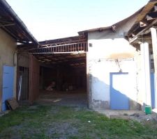 Vue extérieure de la partie à démolir, le long de la façade ouest, accessible par ce large passage entre garage et maison